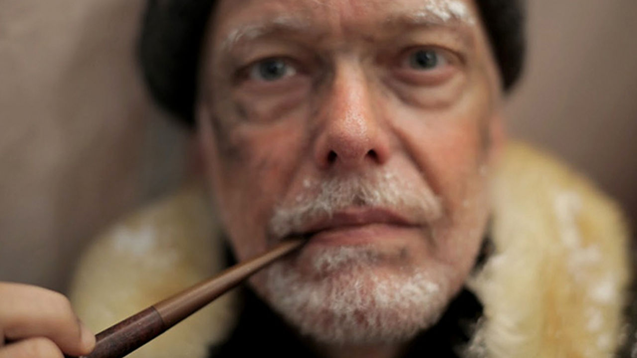 Close-up of an older man smoking a pipe.