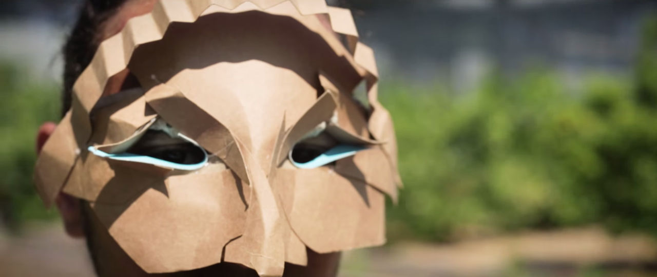 Close-up of man wearing cardboard mask.