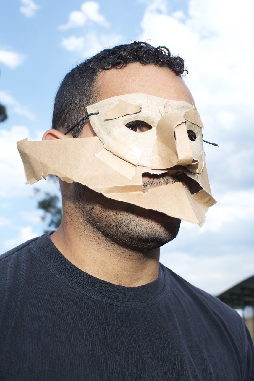 Medium-shot of man wearing cardboard mask.