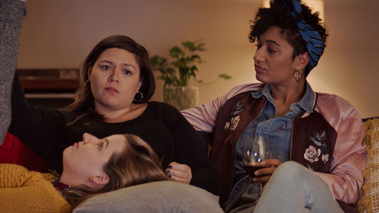 Three women sitting on a couch.